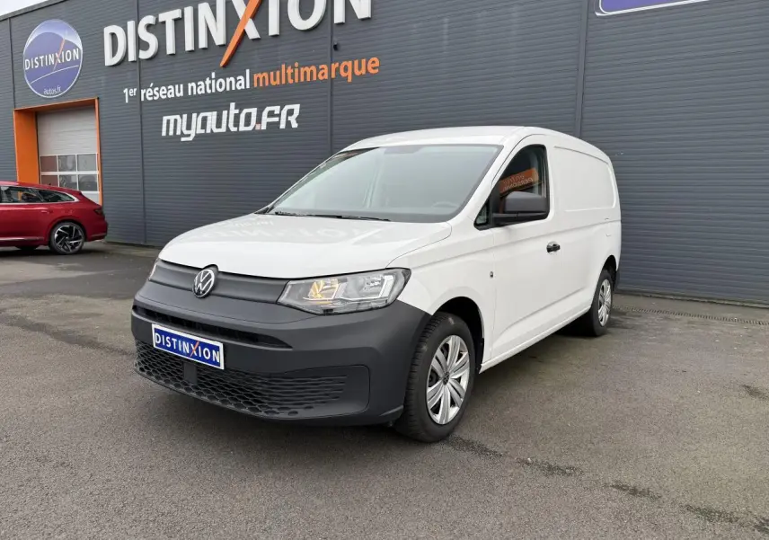 Volkswagen Caddy Maxi Cargo blanc candy en 3/4 avant droit avec pare-chocs noir mat et porte coulissante visible.