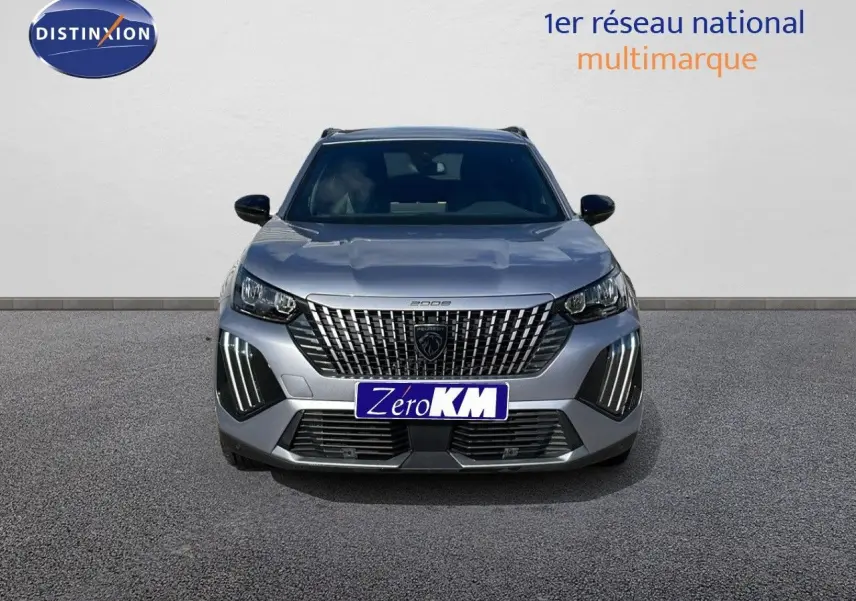 Vue frontale d'un Peugeot 2008 gris Artense métal avec calandre imposante et feux LED verticaux allumés.