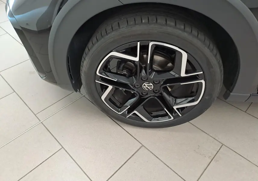 Gros plan sur la roue avant droite du Volkswagen Taigo noir intense nacré avec jante alliage R-Line 18 pouces.