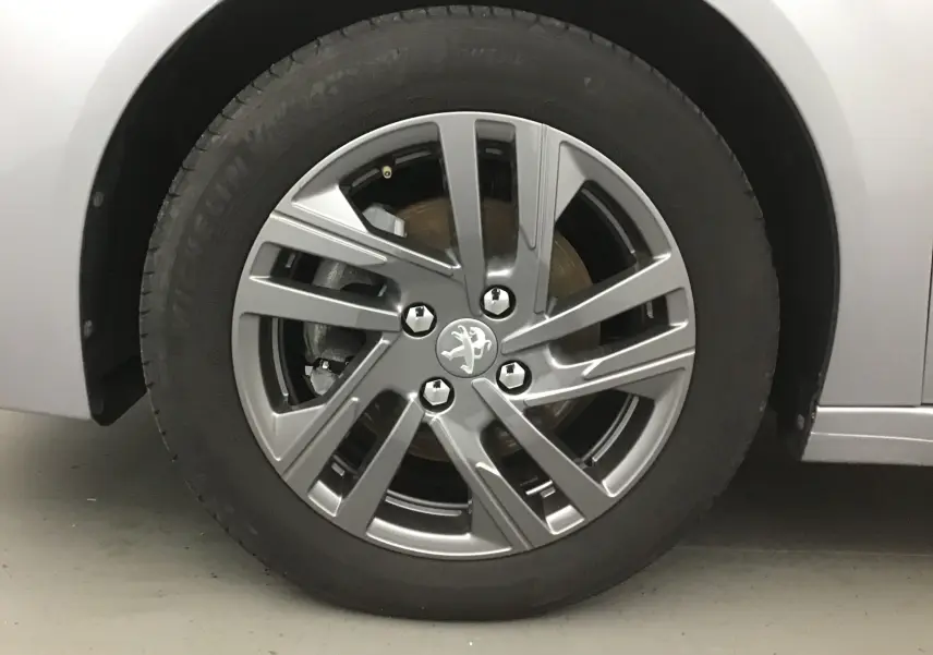 Gros plan sur la roue avant gauche gris Artense d'une Peugeot 208 1.2 PureTech 100 Style avec jante alliage 16 pouces.