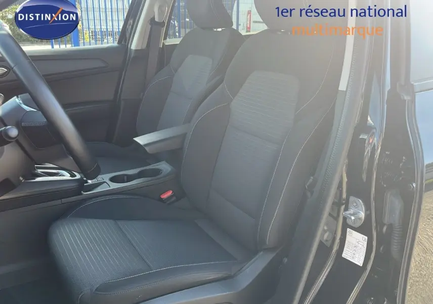 Vue intérieure côté conducteur du Renault Arkana noir métal 2023, sièges tissu gris et console centrale visible.