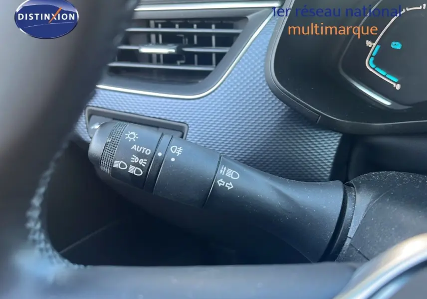 Gros plan sur la commande des feux et clignotants à gauche du volant dans l'habitacle gris du Renault Arkana noir métal 2023.