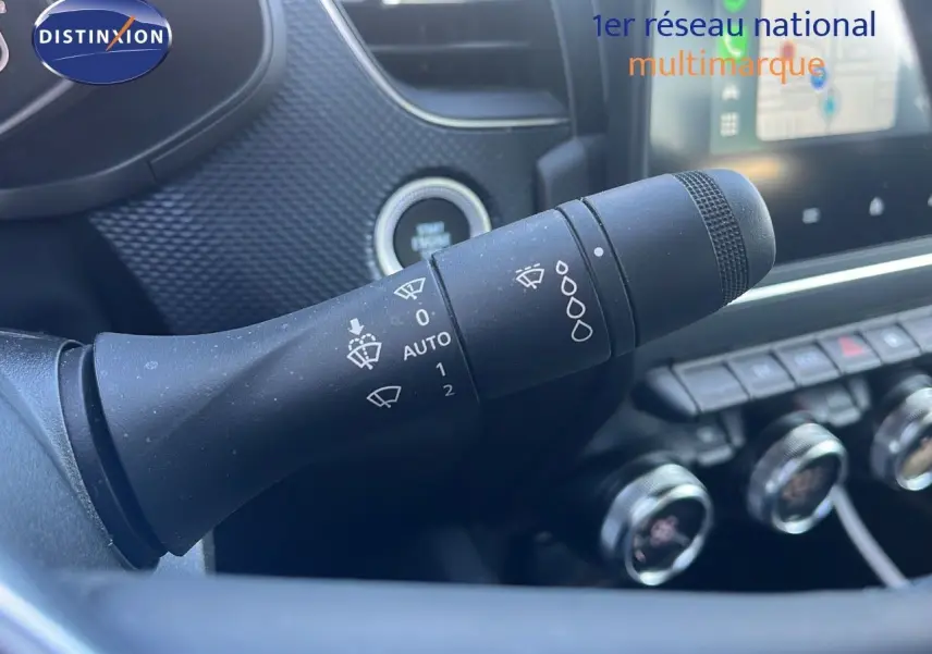 Gros plan sur la commande d'essuie-glace du Renault Arkana noir métal 2023, avec tableau de bord et écran tactile en arrière-plan.