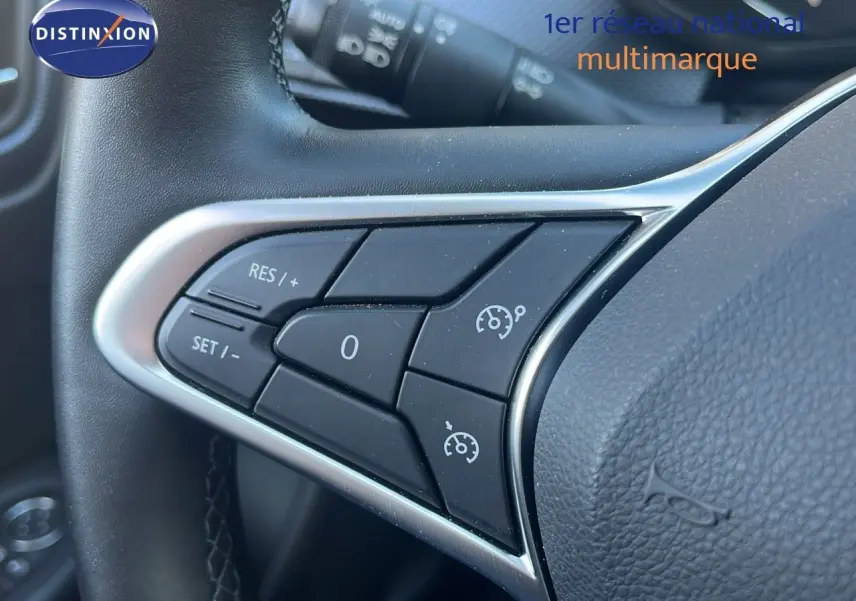 Gros plan sur les commandes de régulateur de vitesse au volant noir du Renault Arkana 2023 hybride.