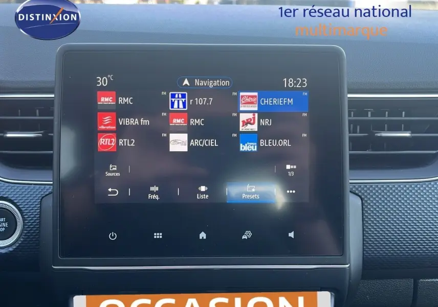 Écran tactile central du tableau de bord du Renault Arkana noir métal 2023 affichant les stations radio FM.