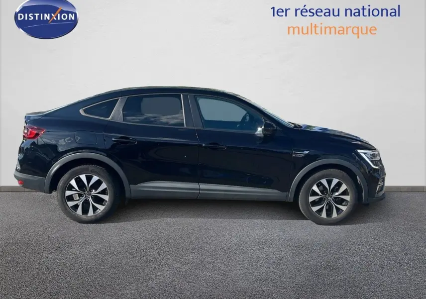 Vue de profil côté gauche du Renault Arkana noir métal 2023, version hybride avec jantes bicolores et lignes fluides.