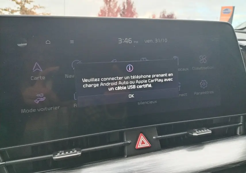 Écran tactile central du Kia Sportage 2025 affichant un message de connexion Android Auto/Apple CarPlay, intérieur noir.