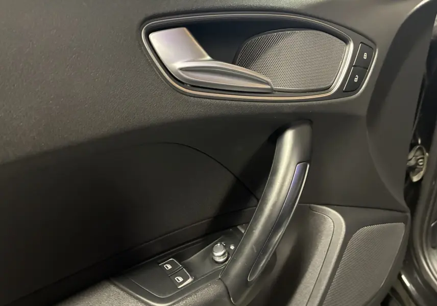 Gros plan sur la poignée intérieure côté gauche de la porte noire d'une Audi A1 1.0 TFSI S-Line de 2016.