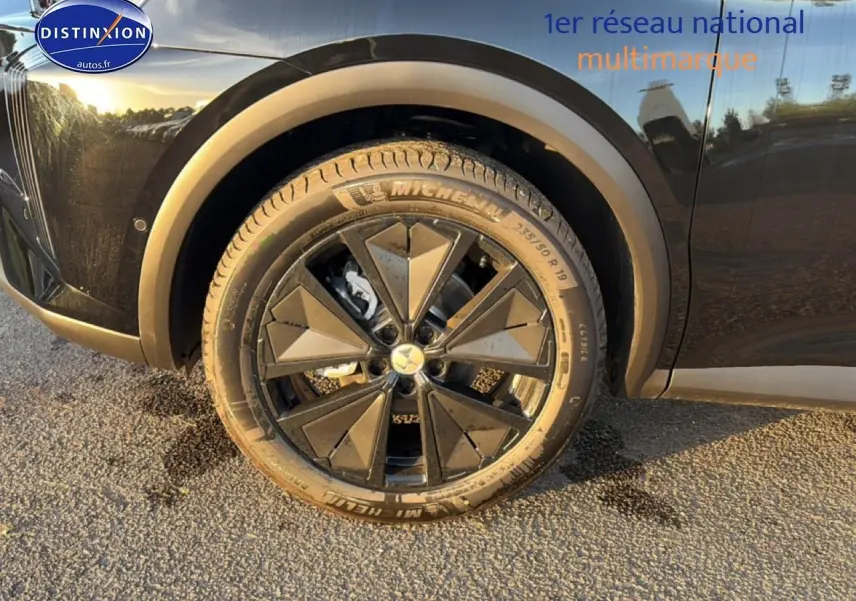 Gros plan sur la roue avant gauche noire avec jante alu au design géométrique du DS7 1.5 BlueHDi 130 Performance Line 2026.