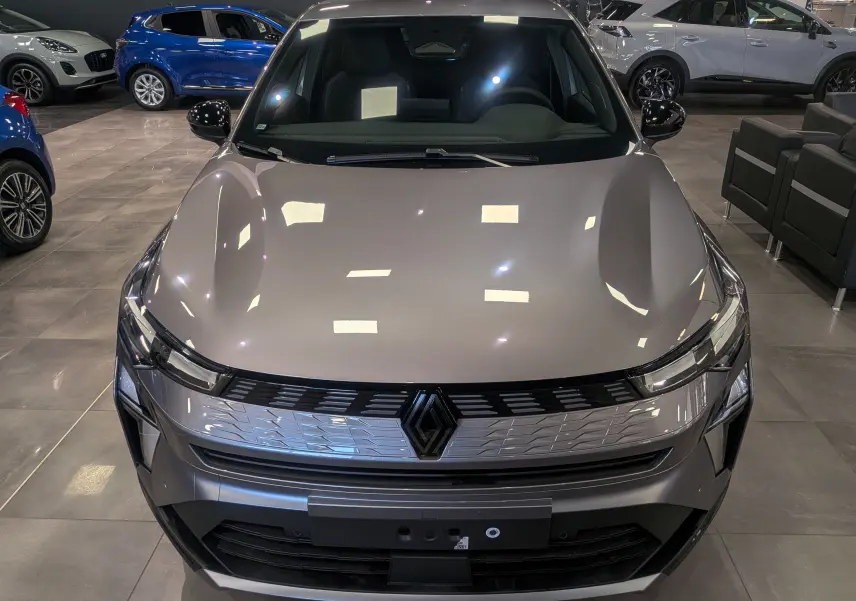 Vue avant d'une Renault SYMBIOZ E-TECH Full Hybrid gris Cassiopé, avec calandre chromée et logo central noir brillant.