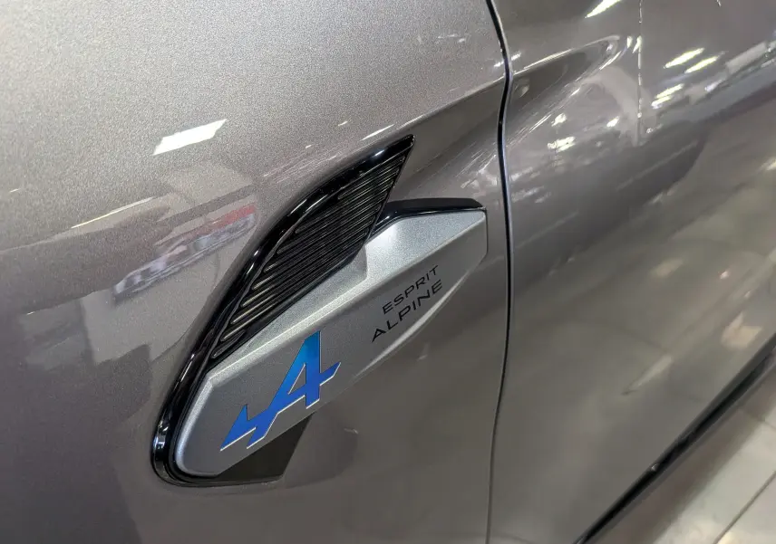 Détail de l'aile avant gauche gris Cassiopé du Renault SYMBIOZ E-TECH avec logo bleu Alpine Esprit.