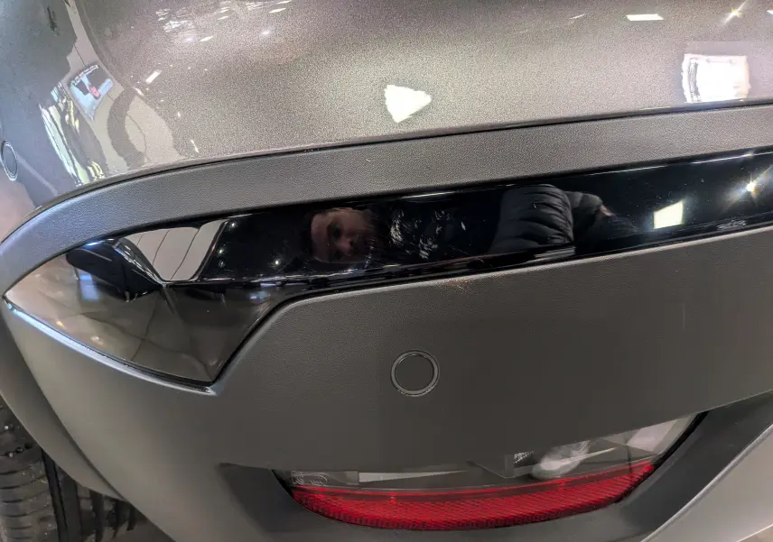 Gros plan sur le feu arrière droit gris Cassiopé du Renault Symbioz E-TECH Full Hybrid 160 CH, avec capteur de stationnement visible.