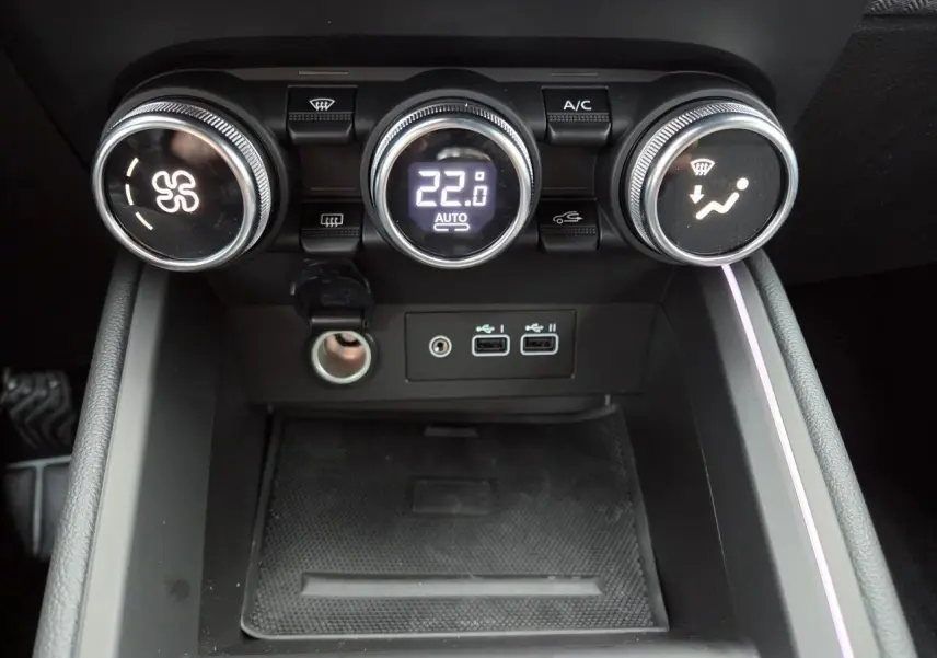 Gros plan sur la console centrale de la Renault Clio 2025 avec commandes de climatisation et ports USB visibles.