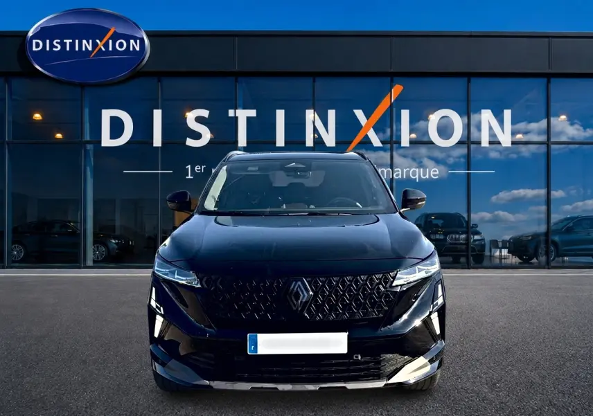 Vue frontale d'un Renault Austral noir avec calandre distinctive et phares LED, devant une vitrine Distinxion.