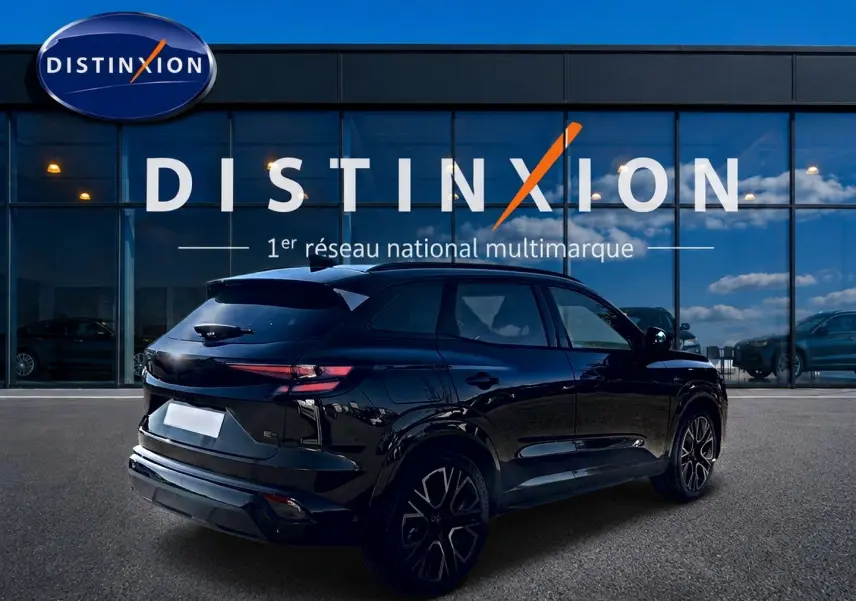 Vue 3/4 arrière droite du Renault Austral noir avec jantes alu et feux arrière LED, devant une vitrine Distinxion.