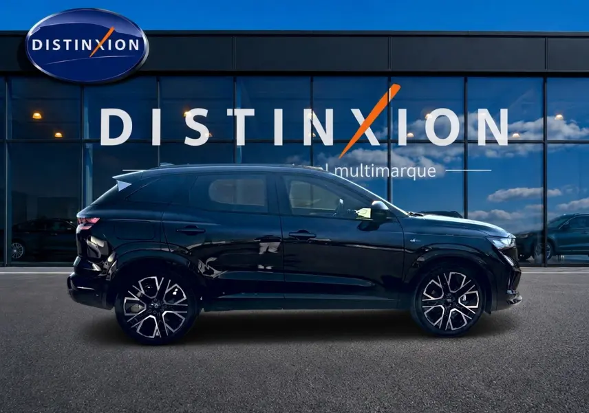 Profil côté gauche du Renault Austral noir 2026 esprit alpine avec jantes alu distinctives, devant une vitrine multimarque.