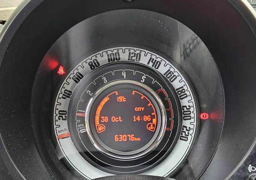 Vue arrière d'une Fiat 500C grise électroclash avec toit rouge, affichant une plaque "OCCASION" sur fond neutre.