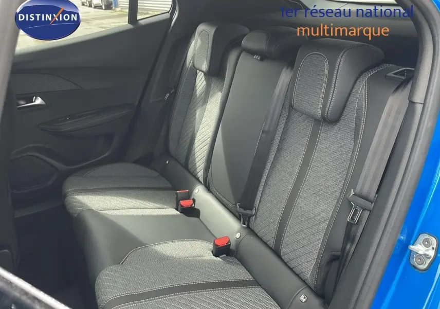 Vue intérieure sur la banquette arrière en tissu et cuir noir du Peugeot 2008 bleu Vertigo 2024, porte arrière droite ouverte.
