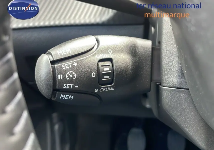 Gros plan sur la commande de régulateur de vitesse du Peugeot 2008 bleu Vertigo Metal, côté gauche du volant.