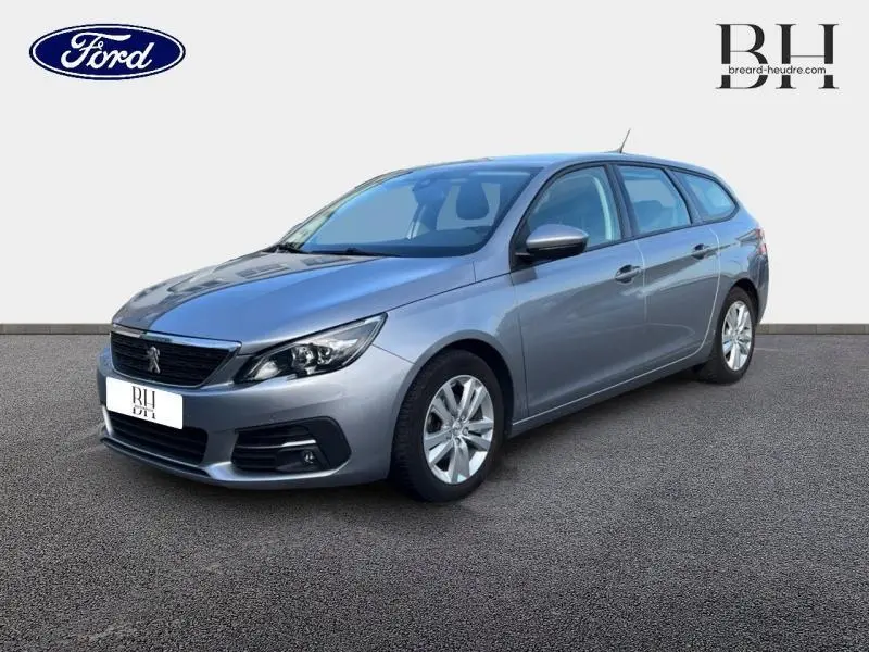 Peugeot 308 SW gris Artense vue 3/4 avant droit, break diesel 2021 avec jantes alu et feux LED.