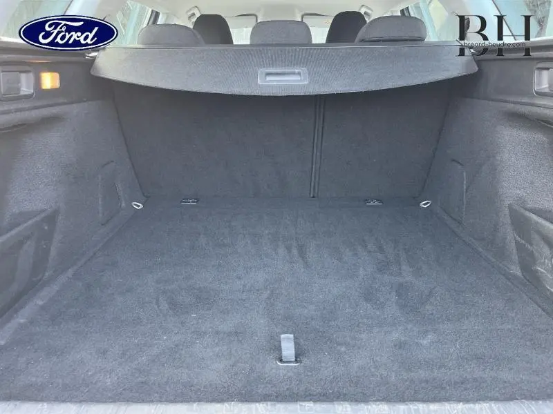 Coffre spacieux et vide de la Peugeot 308 SW gris Artense, vue intérieure arrière avec cache-bagages déployé.