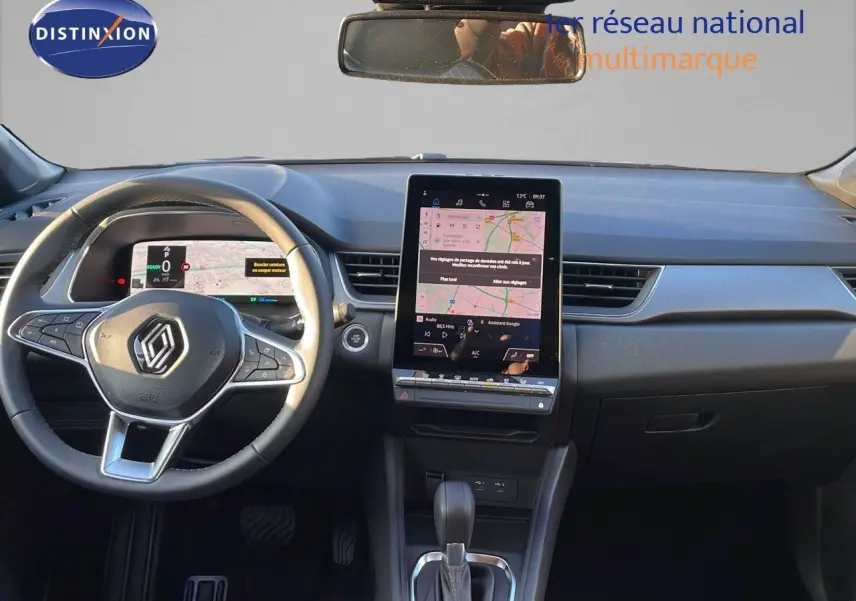 Intérieur du Renault Captur E-Tech 2025, vue frontale sur le tableau de bord avec écran tactile vertical et volant noir.