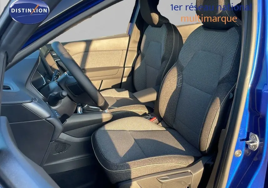 Intérieur avant droit du Renault Captur bleu Iron Metal, sièges tissu gris noir et tableau de bord visible.