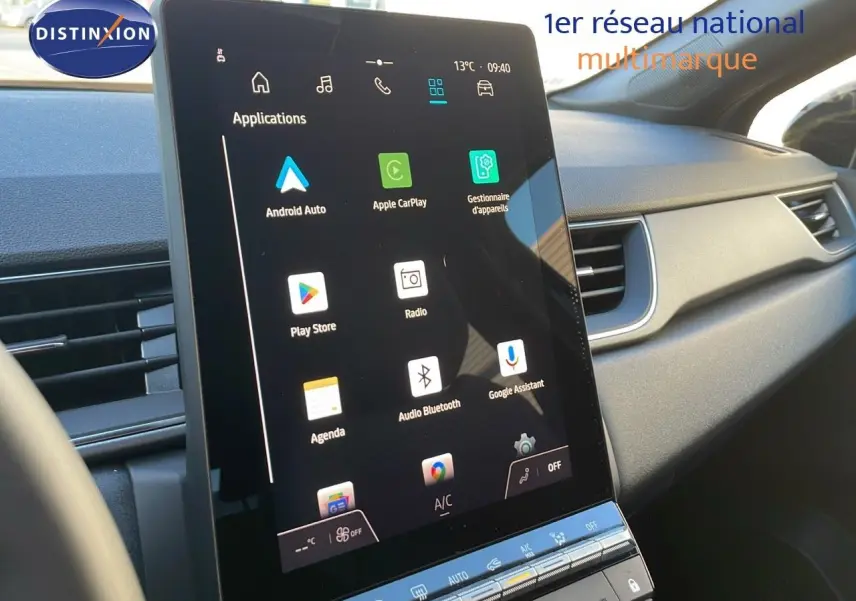 Vue rapprochée de l'écran tactile central du tableau de bord du Renault Captur bleu iron metal avec toit noir, affichant les applications connectées.