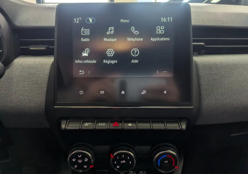 Vue intérieure centrée sur l'écran tactile et la console de commande de la Renault Clio V Blanc Glacier 2025.