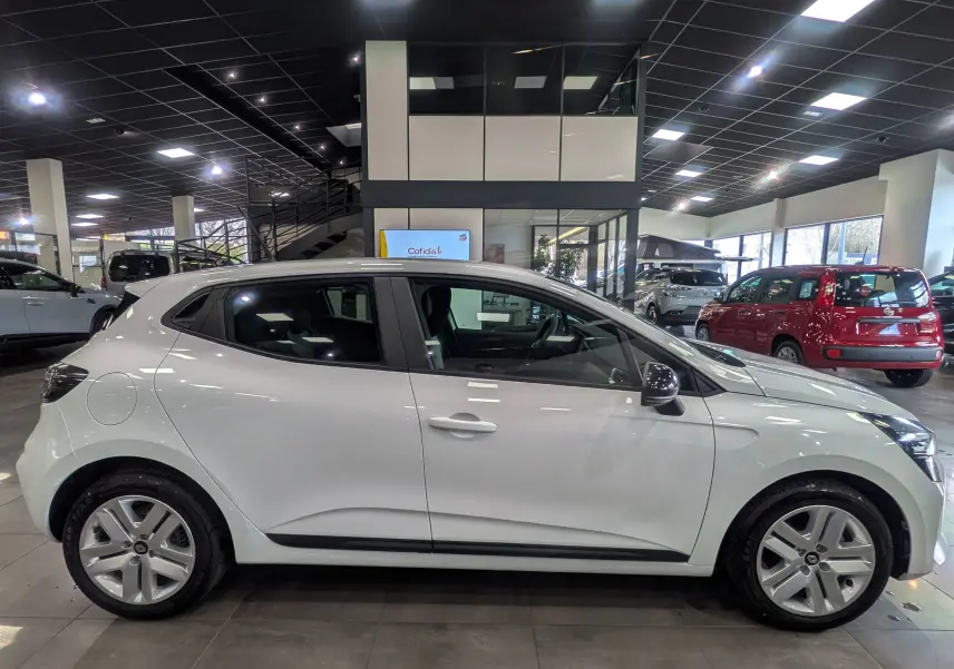 Profil côté gauche d'une Renault Clio V Blanc Glacier 2025 en showroom, soulignant ses lignes épurées et jantes alliage.