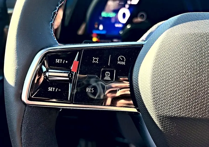 Gros plan sur les commandes de régulateur de vitesse au volant noir du Renault Austral 1.2 e-tech hybride.