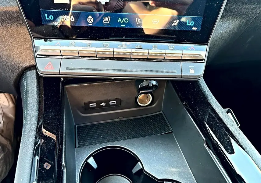 Vue rapprochée de la console centrale noire du Renault Austral 1.2 e-tech, avec ports USB et prise 12V visibles.