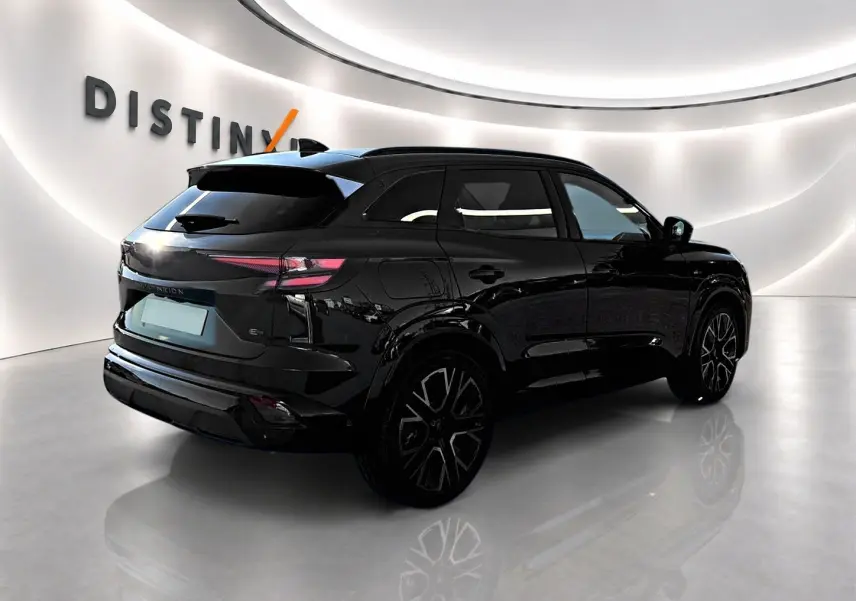 Renault Austral noir en 3/4 arrière droit, avec jantes alu noires et feux arrière LED fins, dans un showroom lumineux.