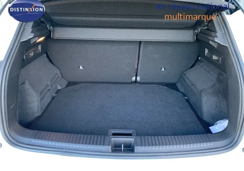 Coffre ouvert du Renault Austral blanc métal avec toit noir, montrant un espace de chargement propre et spacieux.