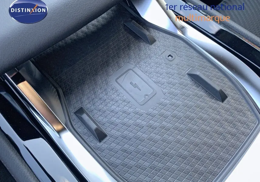 Surface de recharge sans fil noire au centre de la console d'une Renault Austral 2024 blanc métal toit noir.