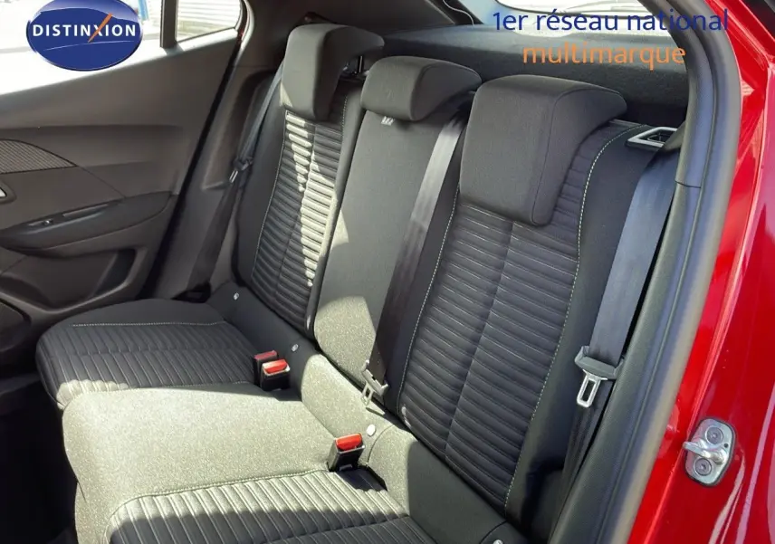 Vue intérieure arrière montrant les sièges noirs avec surpiqûres vertes du Peugeot 2008 rouge Elixir 2025.