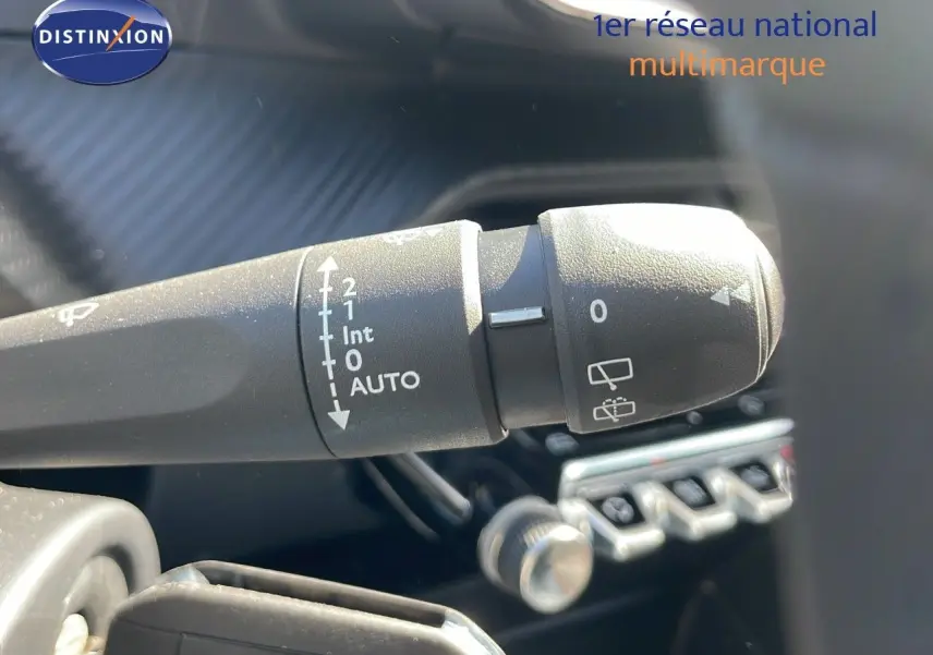 Le commodo d'essuie-glace du Peugeot 2008 2025 en gros plan, avec commandes visibles sur fond intérieur noir.