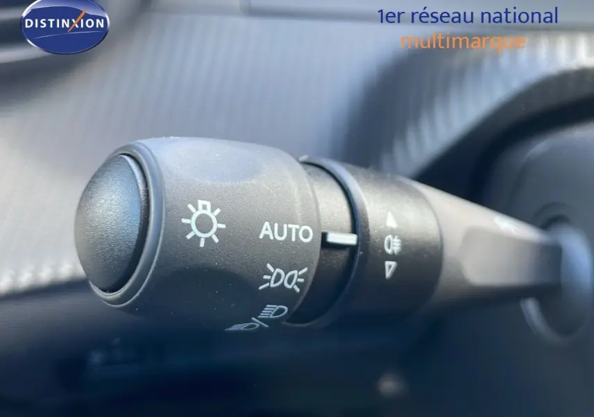 Gros plan sur la commande des phares du Peugeot 2008 2025, version essence rouge Elixir Metal, intérieur noir.