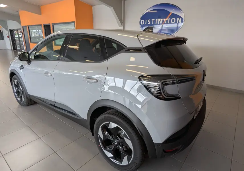 Renault Captur gris zinc vu en 3/4 arrière droit, avec jantes alliage bicolores et vitres arrière surteintées.