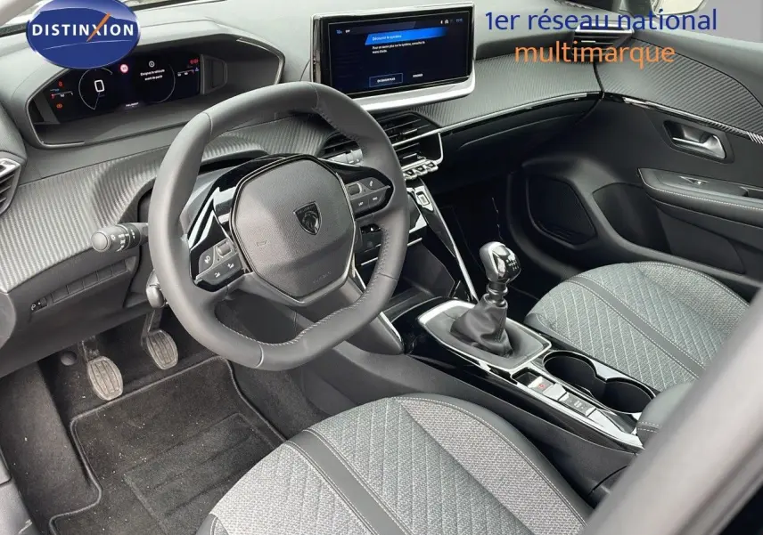 Intérieur avant droit de la Peugeot 208 1.2 PureTech noire, volant compact, tableau de bord numérique et boîte manuelle.