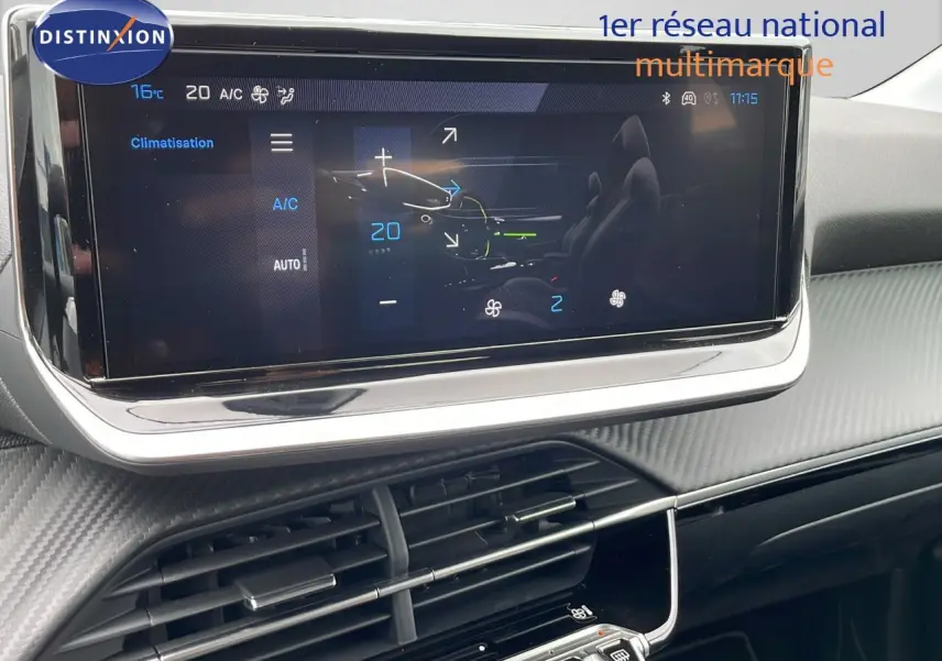 Écran tactile de la climatisation dans l'habitacle moderne d'une Peugeot 208 noire, vue de face rapprochée.