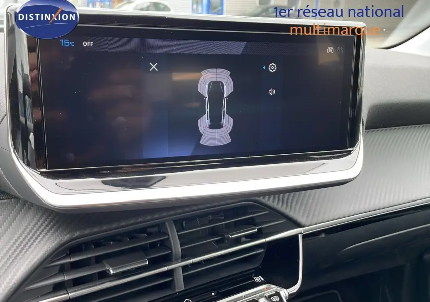 Écran tactile central affichant l'aide au stationnement dans l'habitacle d'une Peugeot 208 noire.