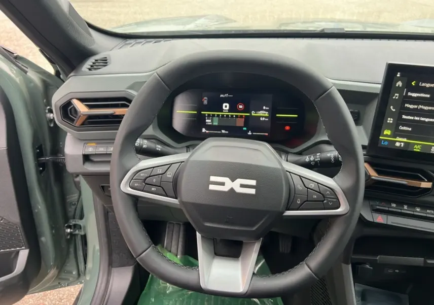 Vue intérieure centrée sur le volant et le tableau de bord numérique du Dacia Duster 2025 kaki lichen, version Extreme Cold Tech.