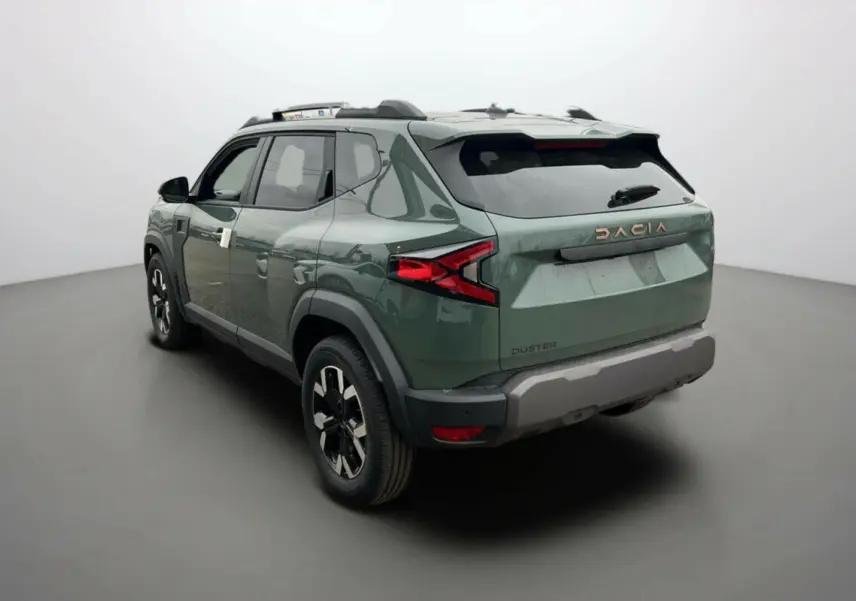 Vue 3/4 arrière droite du Dacia Duster 2025 kaki lichen avec logo cuivre et jantes noires distinctives.
