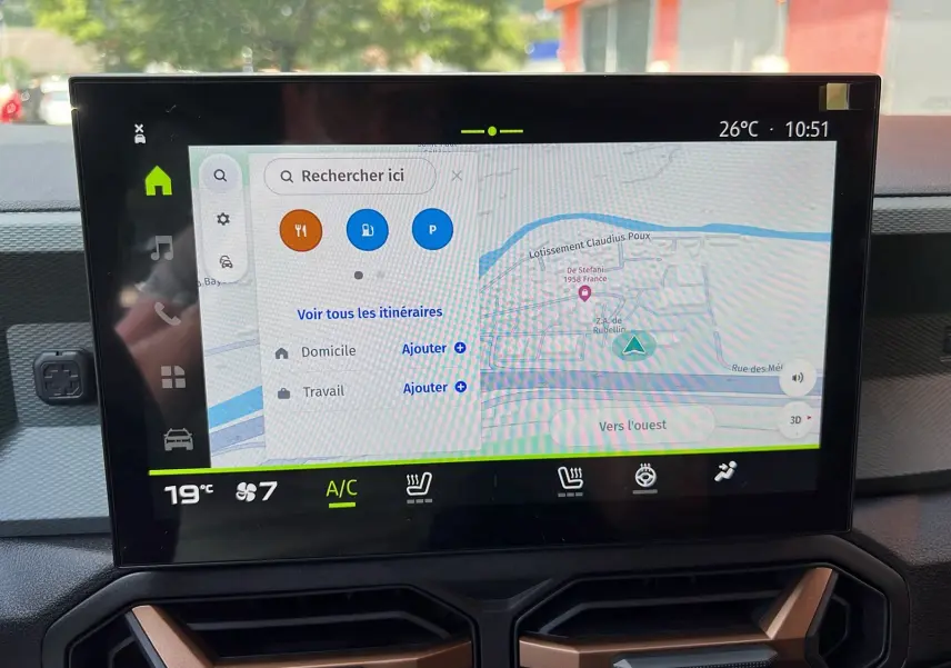 Écran tactile central du tableau de bord du Dacia Duster 2025, affichant la navigation et les commandes climatiques.