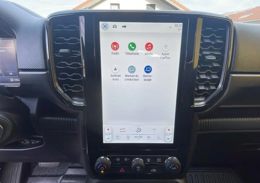 Vue frontale de l'écran tactile 10 pouces du Ford Ranger 2025 gris commander, avec commandes clim et multimédia visibles.