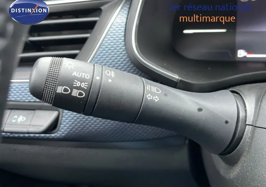 Gros plan sur la manette de commande des phares et clignotants dans l’habitacle du Renault Arkana bleu Zanzibar.