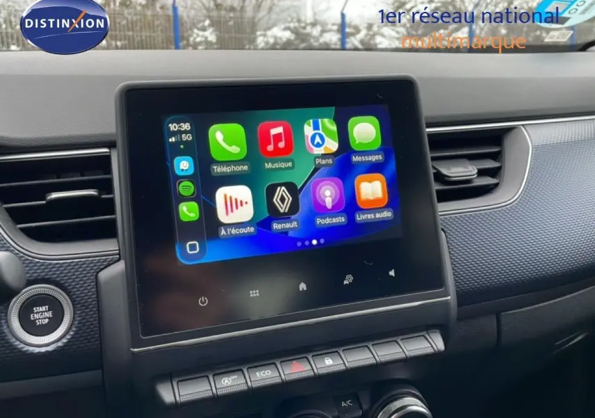 Écran tactile central avec interface Apple CarPlay dans l’habitacle d’une Renault Arkana 2025, tableau de bord noir.