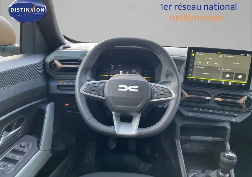 Vue intérieure du tableau de bord du Dacia Duster 2024 noir métal, avec volant multifonctions et écran tactile central.