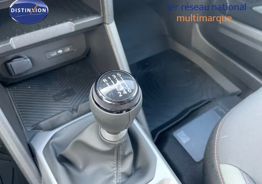 Le levier de vitesses manuel 6 rapports du Dacia Duster 2024, avec console centrale et partie des sièges visibles.